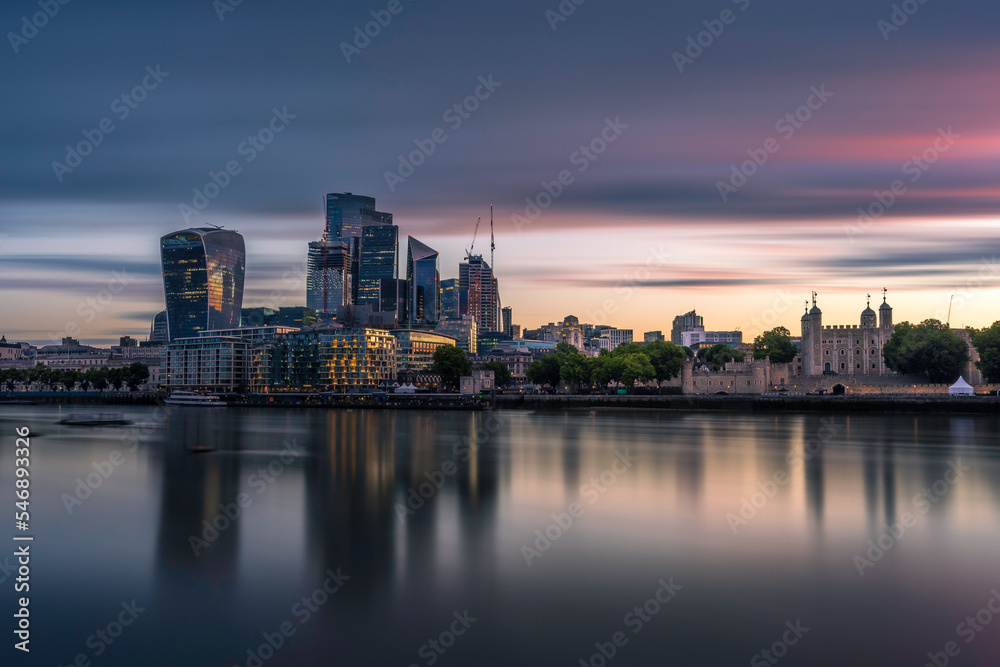 The city and Tower of London, at sunrise.  Long exposure to smooth out the river Thames. The building are reflecting in the water
