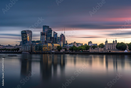 The city and Tower of London  at sunrise.  Long exposure to smooth out the river Thames. The building are reflecting in the water