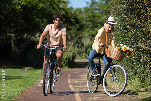 young couple enjoying in a bike ride through the park