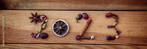 Fototapeta Naklejka Na Ścianę i Meble -  2023 written with Christmas spices and dried fruits on panoramic wooden background, new year web banner