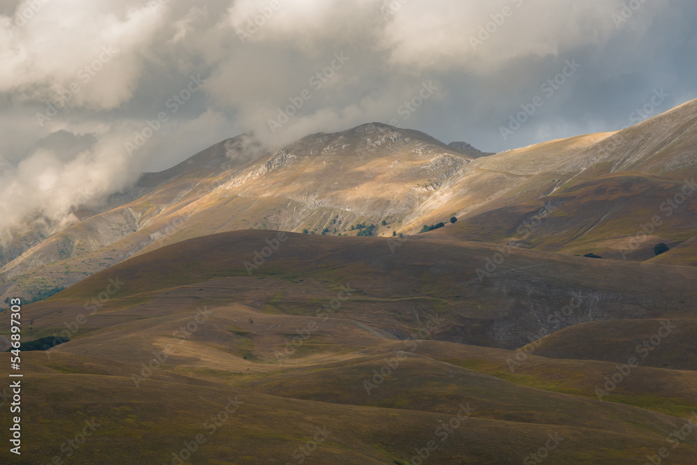 Fototapeta premium View of dark cloud over high mountains near Castelluccio di Norcia in Umbria Italy