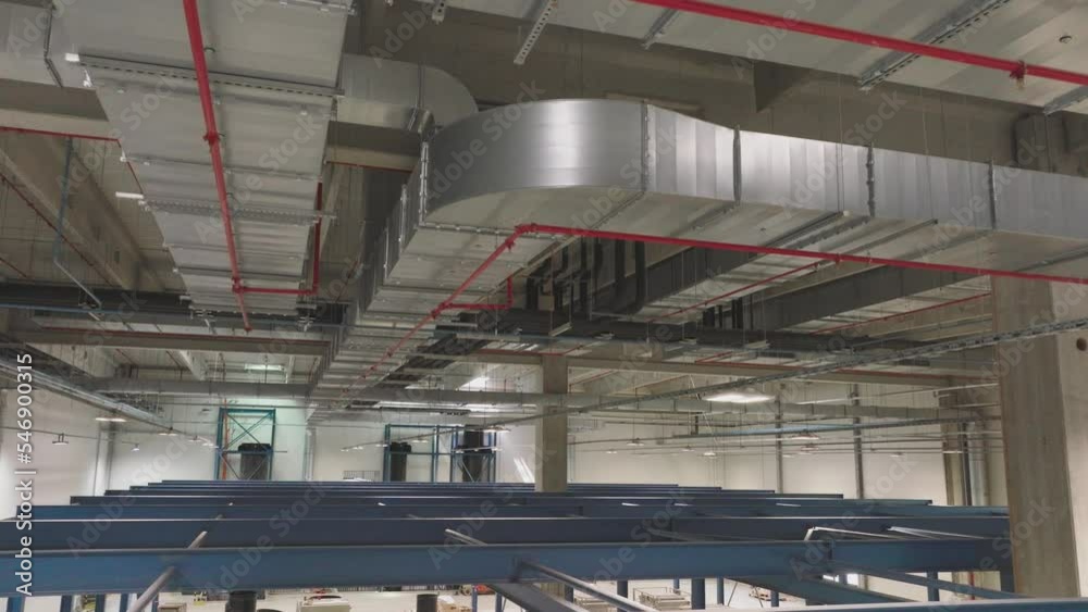 Ventilation system on the ceiling of large buildings. Ventilation pipes hanging from the ceiling inside new factory Ventilation system on the ceiling of large buildings. Ventilation pipes hanging from the ceiling inside new factory