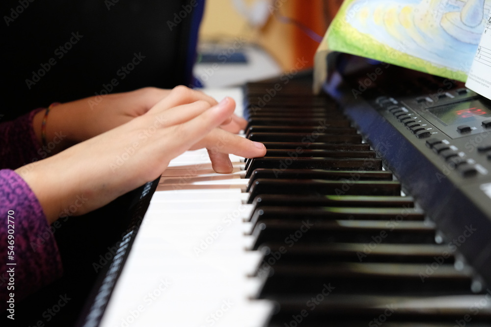 hands of a child playing the piano