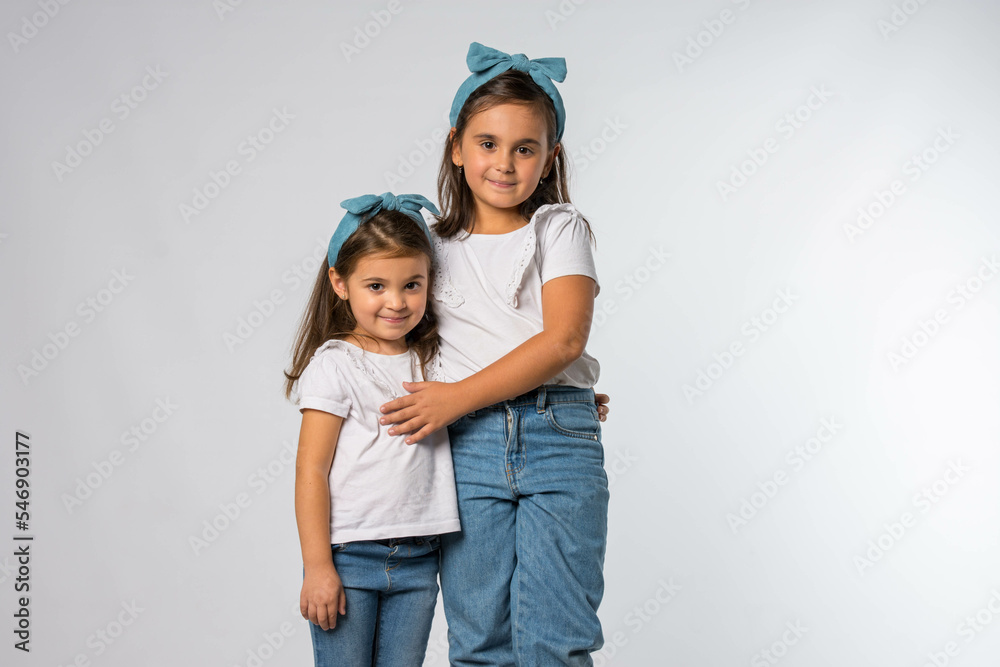 Portrait of two fashionable sisters wearing similar outfits Portrait of two fashionable sisters wearing similar outfits