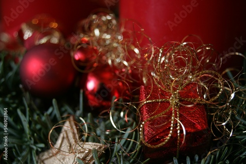 Closeup of a miniature red Christmas present and ornaments for the holidays