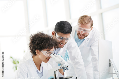 a group of young scientists discussing near the laboratory table