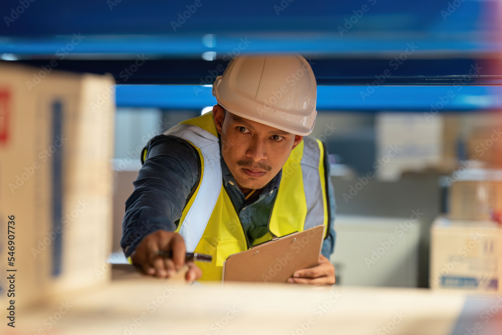 Working at warehouse. Male warehouse worker checking in storage department. Employee organizing goods distribution to the market. Working at warehouse. Male warehouse worker checking in storage department. Employee organizing goods distribution to the market.