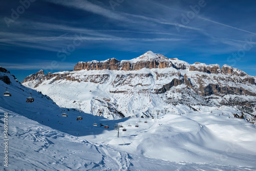 View of a ski resort piste with people skiing in Dolomites in Italy. Ski area Arabba. Arabba  Italy