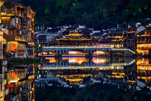 Chinese tourist attraction destination - Feng Huang Ancient Town  Phoenix Ancient Town  on Tuo Jiang River illuminated at night. Hunan Province  China