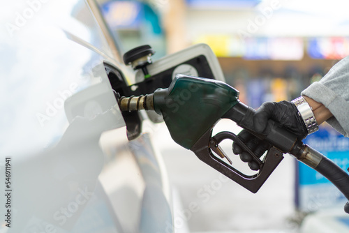 Men fills petrol into his car at a gas station