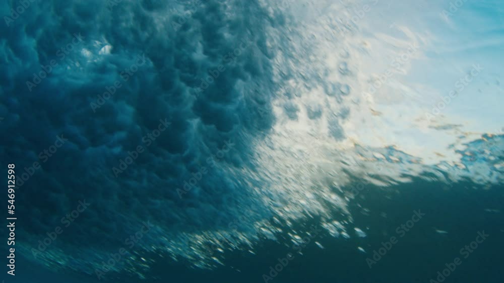 Underwater view of the ocean wave breaking on the shore in the Maldives at sunset Underwater view of the ocean wave breaking on the shore in the Maldives at sunset