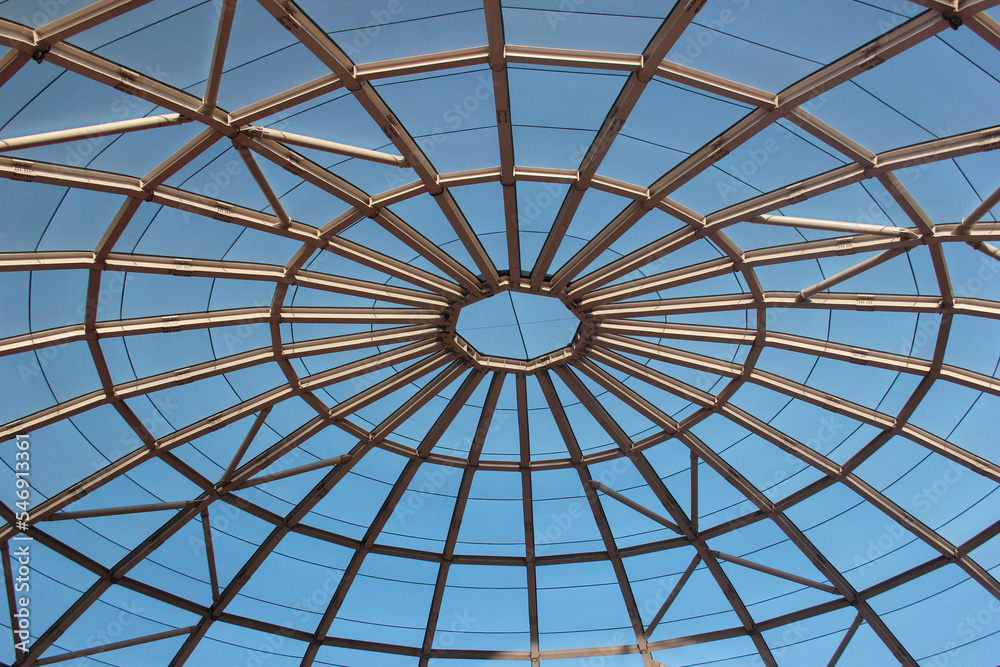 Metal frame of a dome top, interior view with blue sky outside