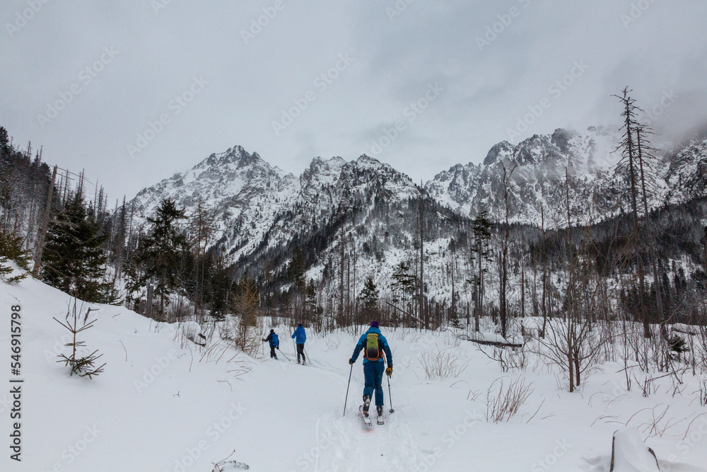 Guide and two backcountry skitourers in snowy High Tatras, the mountain range and national park in Slovakia
