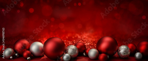 Baubles as a border on a red festive Christmas background with glittering bokeh lights, wide format with copy-space