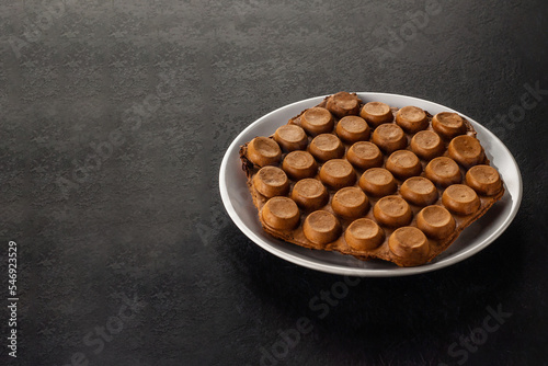 Photography Hong Kong chocolate bubble waffle on dark background with copy space