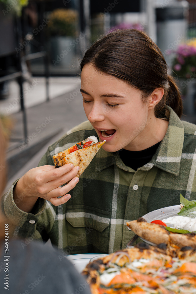 Terrace, meeting friends in a restaurant - woman girl eating tasty pizza