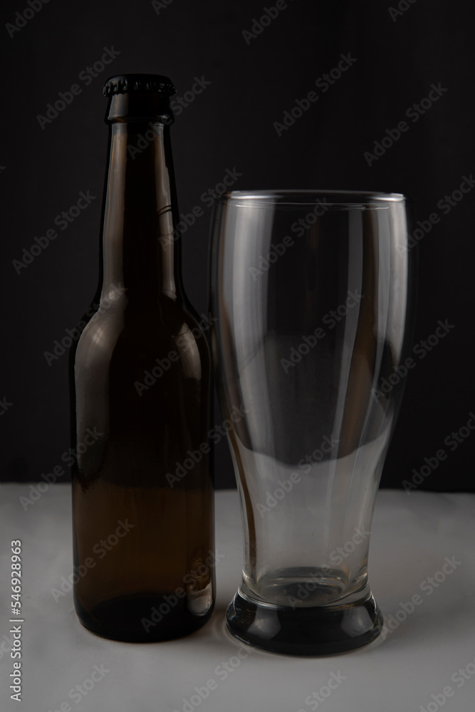 a bottle of beer and a glass on a black background