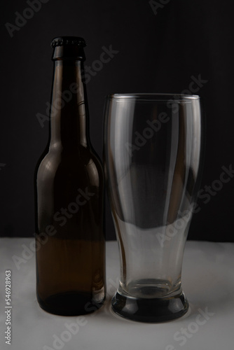 a bottle of beer and a glass on a black background