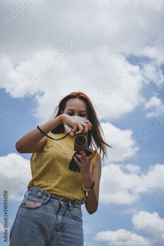 Young woman traveller using her camera ,beautiful cloud and sky in backgroung