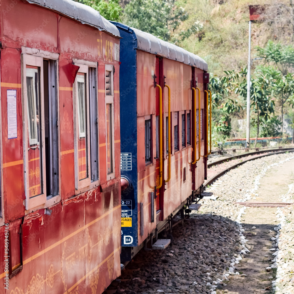 Toy Train moving on mountain slopes, beautiful view, one side mountain, one side valley moving on railway to the hill, among green natural forest. Toy train from Kalka to Shimla in India, Indian Train