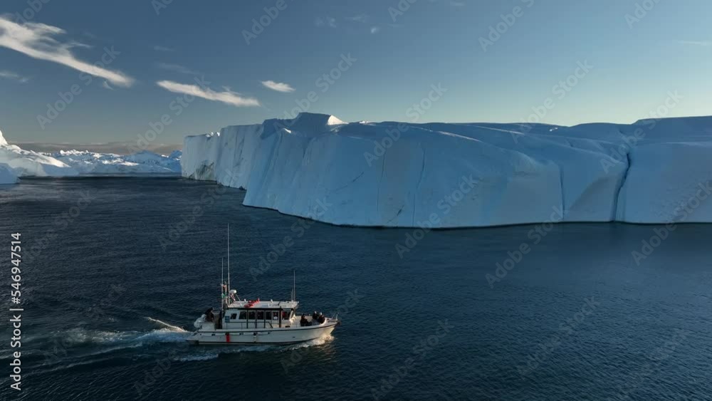 barco navegando cerca de grandes icebergs.