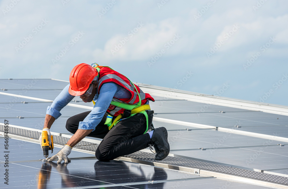 Engineer working setup Solar panel at the roof top. Engineer or worker work on solar panels or solar cells on the roof of business building Engineer working setup Solar panel at the roof top. Engineer or worker work on solar panels or solar cells on the roof of business building