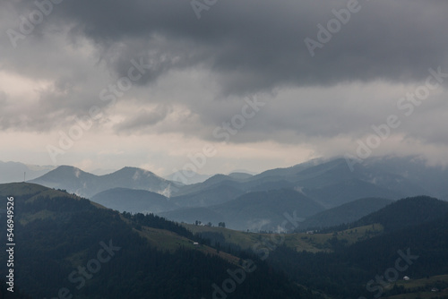 Dark forest mountain range in a misty gray deep fog in the Carpathians mountains, Chornogora, Ukraine