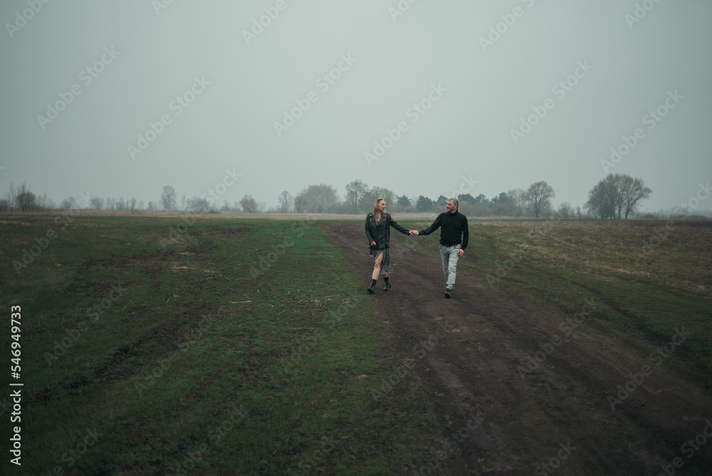 Fototapeta premium Happy couple in love in casual clothes travel together, hike and walk in the autumn forest in nature, selective focus