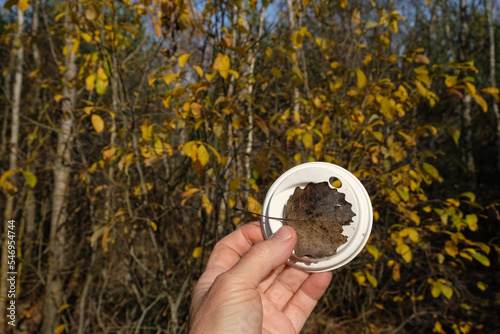 фотографія Disposable lid for paper cup in woman's hand