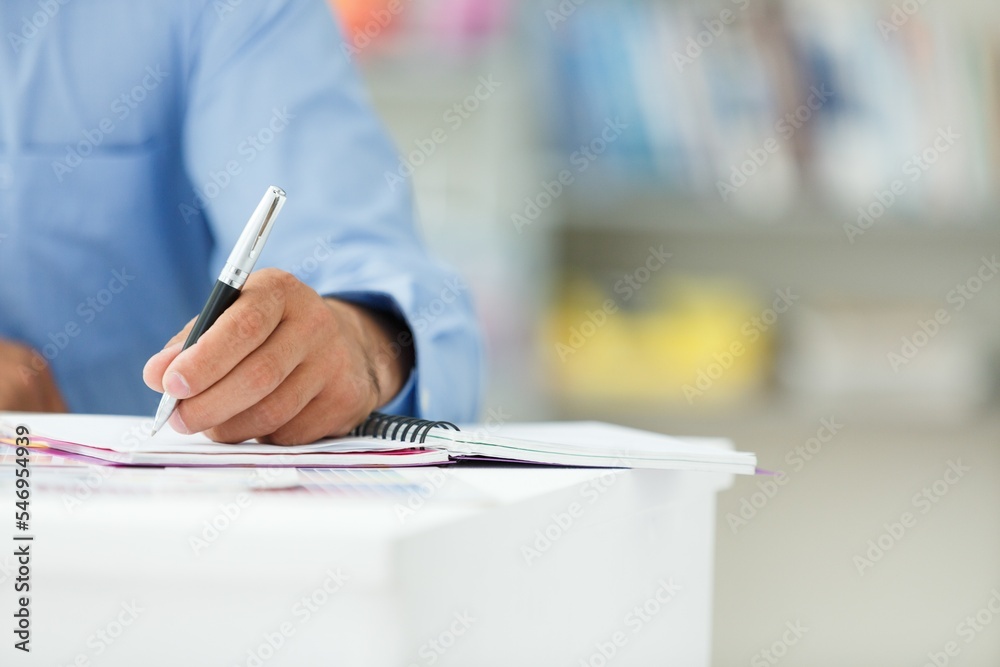 Man hand with writing pen on notebook. Office workplace. Man hand with writing pen on notebook. Office workplace.