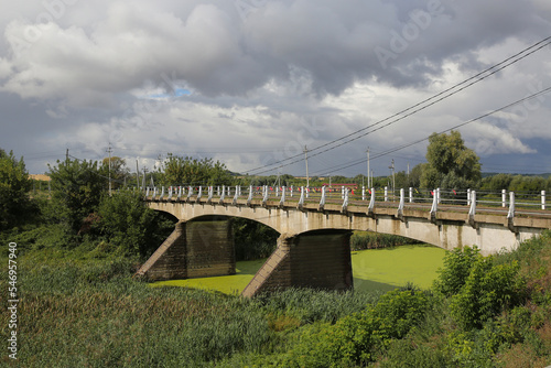 the old bridge over the river with blooming green water, the bridge was built in 1910 photo