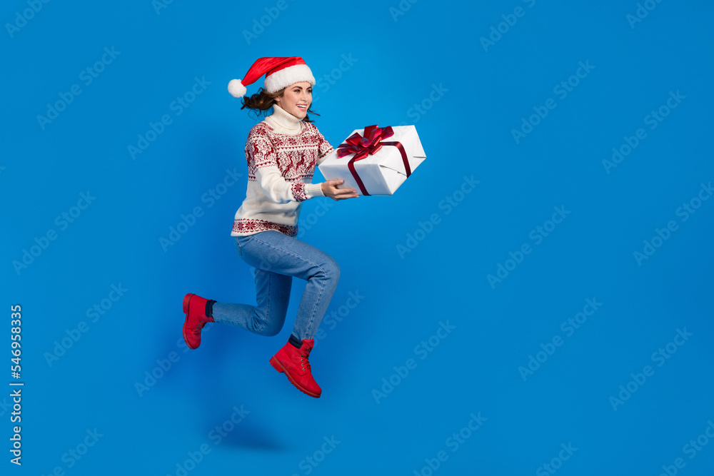 Full length photo of funky positive lady hold gift hurry store mall center empty space season discount isolated on blue color background Full length photo of funky positive lady hold gift hurry store mall center empty space season discount isolated on blue color background