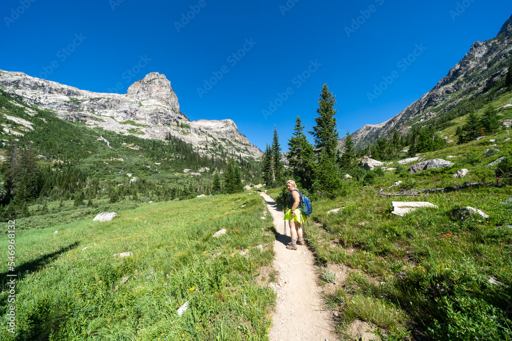 Woman backpacker hikes along the Cascade Canyon trail in Grand Teton National Park, looking angry and upset
