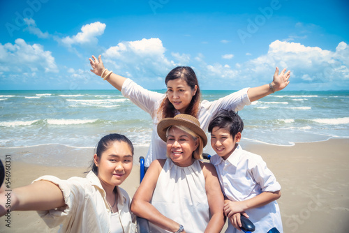 Happy Asian diversity generation family standing on tropical beach in summer at daytime