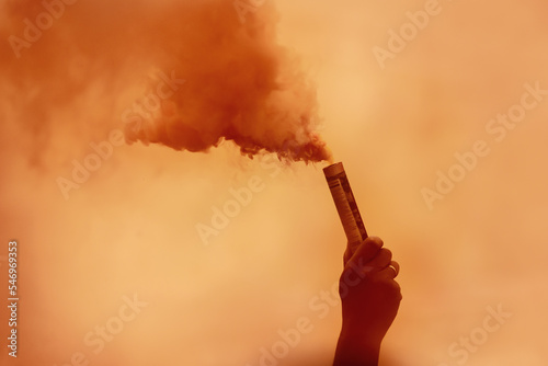 orange smoke bomb in hand. A man is holding colored orange smoke. Formula 1 fans. Redbull Ring 2022.Dutch F1 fans.