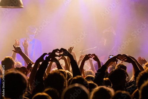 Tłum fanów robi serca z rąk na koncercie