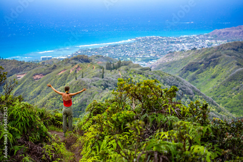 hiker girl enjoys the panorama of oahu island and honolulu in hawaii islands while climbing wiliwilinui ridge trail; hiking on green mountains in hawaii, holidays in hawaii photo