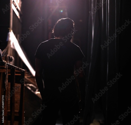 Back view of a male walking backstage under illuminated lights Fototapet