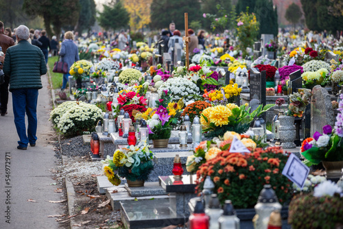 Groby na cmentarzu ze zniczami i kwiatami