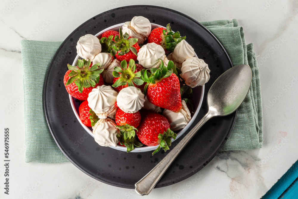 Strawberry dessert with dulce de leche meringue, served in a bowl on a marble background Strawberry dessert with dulce de leche meringue, served in a bowl on a marble background
