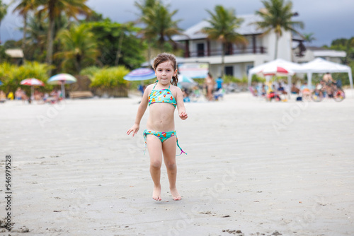 garotinha de 3 anos brincando na praia
