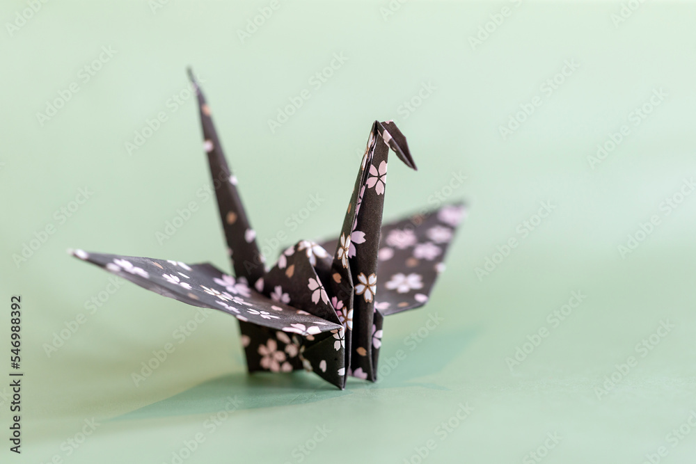 Origami crane on a pale mint background