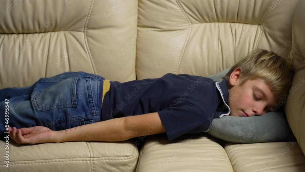 Tired exhausted teen falling down on sofa at home after hard working day. Bored boy falls on couch pillow, burnout homework concept. Cute teen boy lying on couch while taking nap at living room Tired exhausted teen falling down on sofa at home after hard working day. Bored boy falls on couch pillow, burnout homework concept. Cute teen boy lying on couch while taking nap at living room