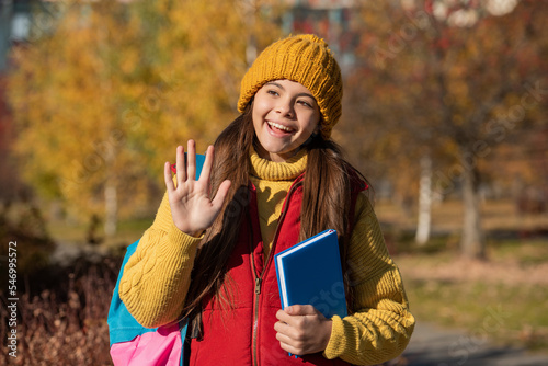 happy teen girl back to school in autumn. hello