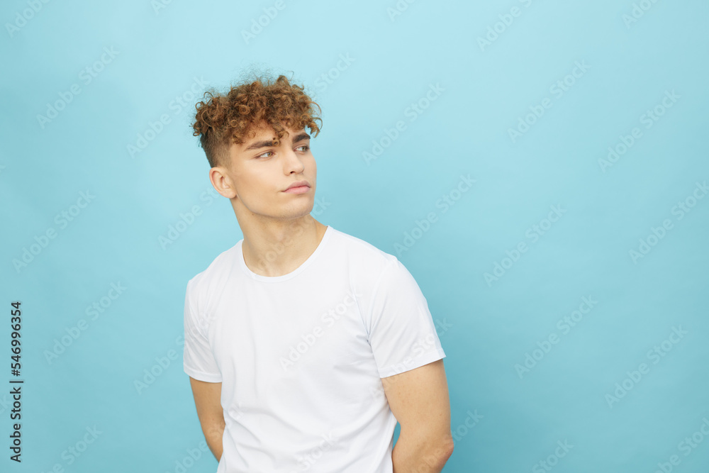 horizontal isolated portrait of a handsome man with curly hair smiling pleasantly looking to the side, standing in a casual white T-shirt posing relaxed horizontal isolated portrait of a handsome man with curly hair smiling pleasantly looking to the side, standing in a casual white T-shirt posing relaxed