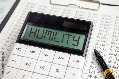 HUMILITY - text on the calculator screen on the table with documents