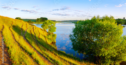 Sunny morning landscape with blue river and green fields