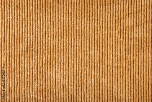 Texture of ribbed velvet. Texture of velvet fabric in light brown color with vertical stripes.