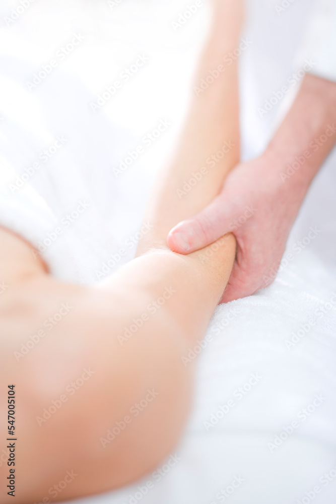 Massage Therapist Practitioner examines the ellbow of his female patient Massage Therapist Practitioner examines the ellbow of his female patient