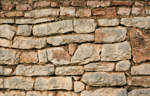 Stone wall for background design. A backing with natural stones for branding  calendar  screensaver  wallpaper  poster  banner  cover  website. A place for your design or text. High quality photo